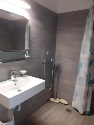 a bathroom with a sink and a shower with a mirror at Breezy summer maisonette with exciting view! in Aghia Marina