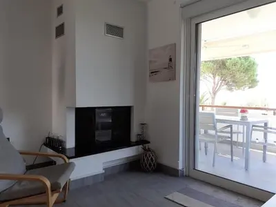 a living room with a fireplace and a sliding glass door at Breezy summer maisonette with exciting view! in Aghia Marina