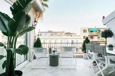 a balcony with white chairs and a table and a plant at Acropolis Veranda Residence in Athens