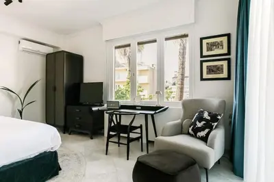 a bedroom with a bed and a desk and a chair at Acropolis Veranda Residence in Athens