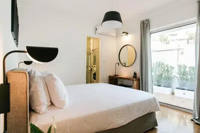 a bedroom with a bed with a mirror and a window at Acropolis Veranda Residence in Athens