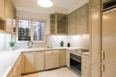 a kitchen with wooden cabinets and a sink and a window at Acropolis Veranda Residence in Athens