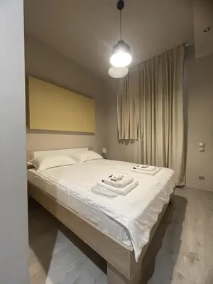 a bedroom with a white bed with towels on it at WUKELA APARTMENTS in Athens