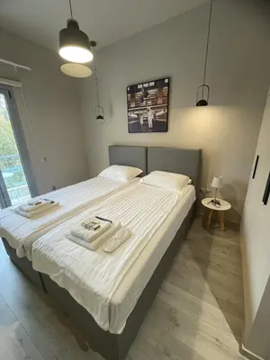 a bedroom with a large bed with white sheets at WUKELA APARTMENTS in Athens