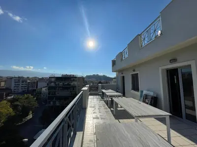 a balcony with benches and tables on a building at WUKELA APARTMENTS in Athens