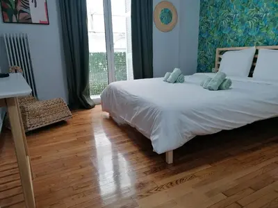 a bedroom with a large white bed with blue pillows at Boho Studio / Hilton Area-Μέγαρο Μουσικής / Athens in Athens