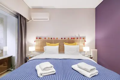 a bedroom with a blue and white bed with towels on it at Bang in Kolonaki by Athenian Homes in Athens