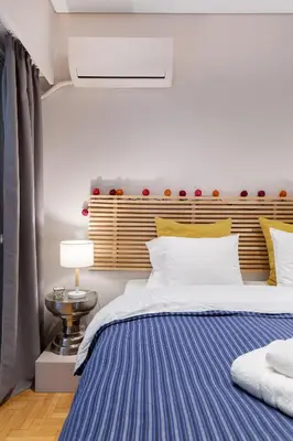 a bedroom with a large bed with a blue blanket at Bang in Kolonaki by Athenian Homes in Athens