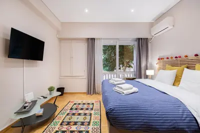 a bedroom with a large bed with a tv on the wall at Bang in Kolonaki by Athenian Homes in Athens