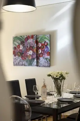 a dining room with a table and two paintings on the wall at 3BR Prime APT a breath away from the Acropolis! in Athens