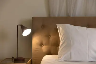 a bed with a white pillow and a lamp at 3BR Prime APT a breath away from the Acropolis! in Athens