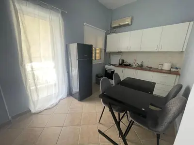 a kitchen with a black table and a refrigerator at Nikea apartment near Piraeus port and metro st II in Piraeus