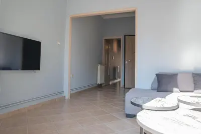 a living room with a couch and a flat screen tv at Nikea apartment near Piraeus port and metro st II in Piraeus