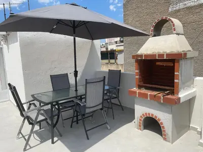 a table and chairs with an umbrella on a patio at Nikea apartment near Piraeus port and metro st II in Piraeus