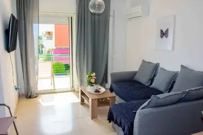 a living room with a blue couch and a table at Eclectic Apartment with Stunning Seaview in Porto Rafti