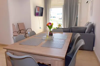 a dining room table with chairs and a couch at Eclectic Apartment with Stunning Seaview in Porto Rafti