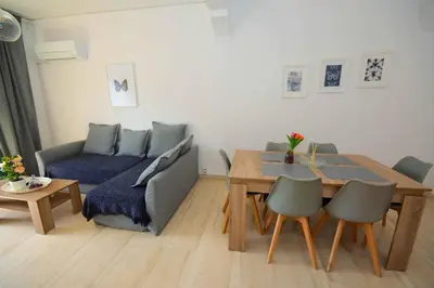 a living room with a blue couch and a table at Eclectic Apartment with Stunning Seaview in Porto Rafti