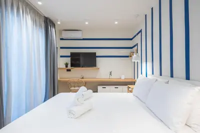 a bedroom with a large white bed with towels on it at The Asprogeraka - self check-in rooms in Athens