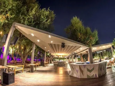 a pavilion with tables and chairs on a deck at night at Xcite Hotel Salem in Athens