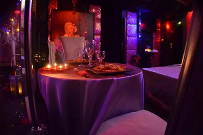 a purple table with a plate of food and candles at Xcite Hotel Salem in Athens