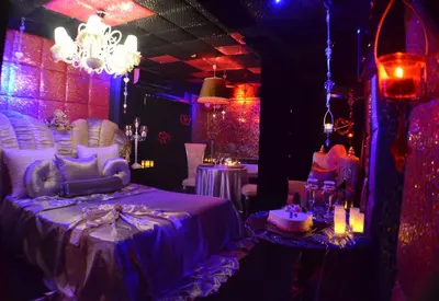 a room with purple lighting and a bed and tables at Xcite Hotel Salem in Athens