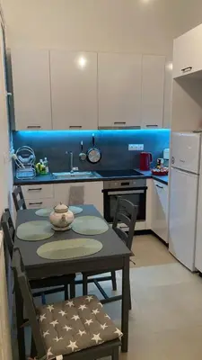 a kitchen with a table and chairs and a refrigerator at Chris AKROPOLI in Athens