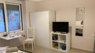 a living room with a television on a white cabinet at Chris AKROPOLI in Athens