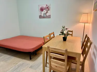 a room with a table and a bed and a table and chairs at Sun Beach Apartment in Anavissos