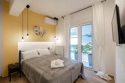 a bedroom with a bed and a sliding glass door at Calliope Apartment in Athens