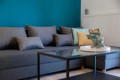 a couch with pillows and a table in a living room at Calliope Apartment in Athens