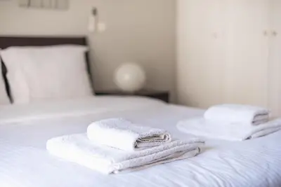 two towels are stacked on top of a bed at Pame Rentals - Entire Apartment with Free Parking in Athens