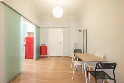 a dining room with a table and chairs and a red refrigerator at Pame Rentals - Entire Apartment with Free Parking in Athens