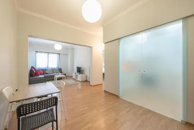 a living room with a table and a sliding glass door at Pame Rentals - Entire Apartment with Free Parking in Athens