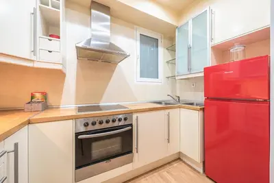a kitchen with white cabinets and a red refrigerator at Pame Rentals - Entire Apartment with Free Parking in Athens