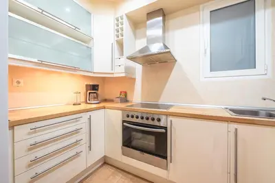 a kitchen with white cabinets and a stove top oven at Pame Rentals - Entire Apartment with Free Parking in Athens