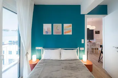 a blue bedroom with a bed and a blue wall at Aphrodite Apartment in Athens