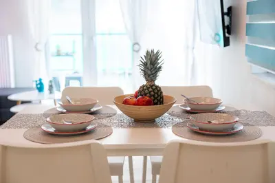 a table with a bowl of fruit and a pineapple on it at Aphrodite Apartment in Athens