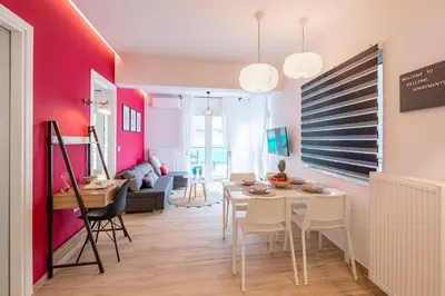 a dining room and living room with a table and chairs at Aphrodite Apartment in Athens