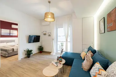 a living room with a blue couch and a bed at Hestia Apartment in Athens