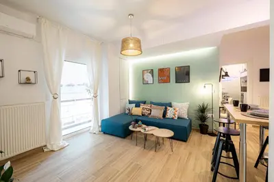 a living room with a blue couch and a window at Hestia Apartment in Athens