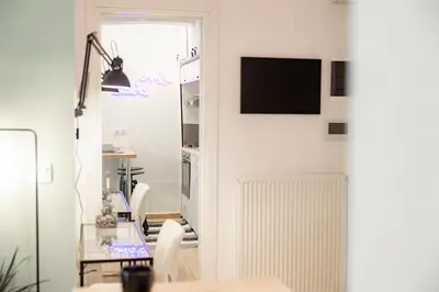 a dining room with a table and a tv on a wall at Hestia Apartment in Athens