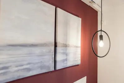 a light fixture hanging on a wall next to two paintings at Hestia Apartment in Athens