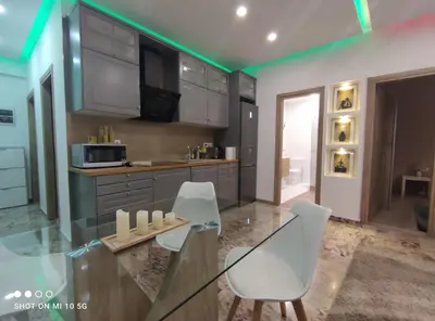 a kitchen with a glass table and white chairs at Lovely luxury apartment Sokratous 133, Kallithea in Athens