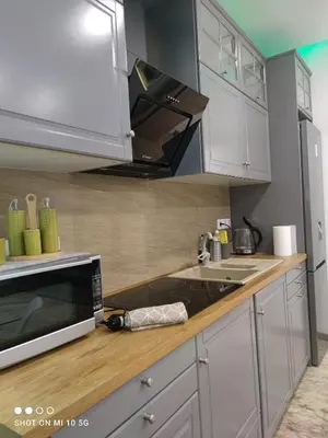 a kitchen with white cabinets and a microwave at Lovely luxury apartment Sokratous 133, Kallithea in Athens