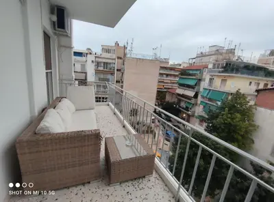 a balcony with a couch and a view of buildings at Lovely luxury apartment Sokratous 133, Kallithea in Athens