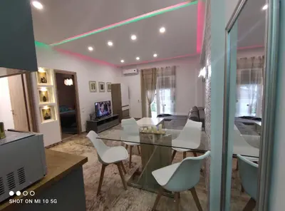 a living room with a glass table and white chairs at Lovely luxury apartment Sokratous 133, Kallithea in Athens