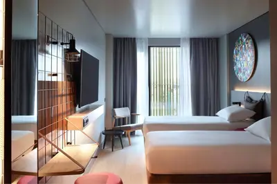 a hotel room with two beds and a television at Moxy Athens City in Athens
