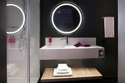 a bathroom with a white sink and a mirror at Moxy Athens City in Athens