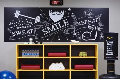 a wall with a sign that says sweat smile and repeat at Moxy Athens City in Athens