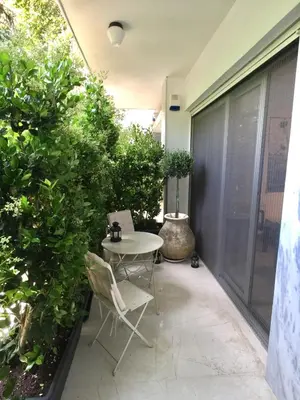 a patio with a table and chairs and plants at Vibrant Urban Chic Apartment in Athens